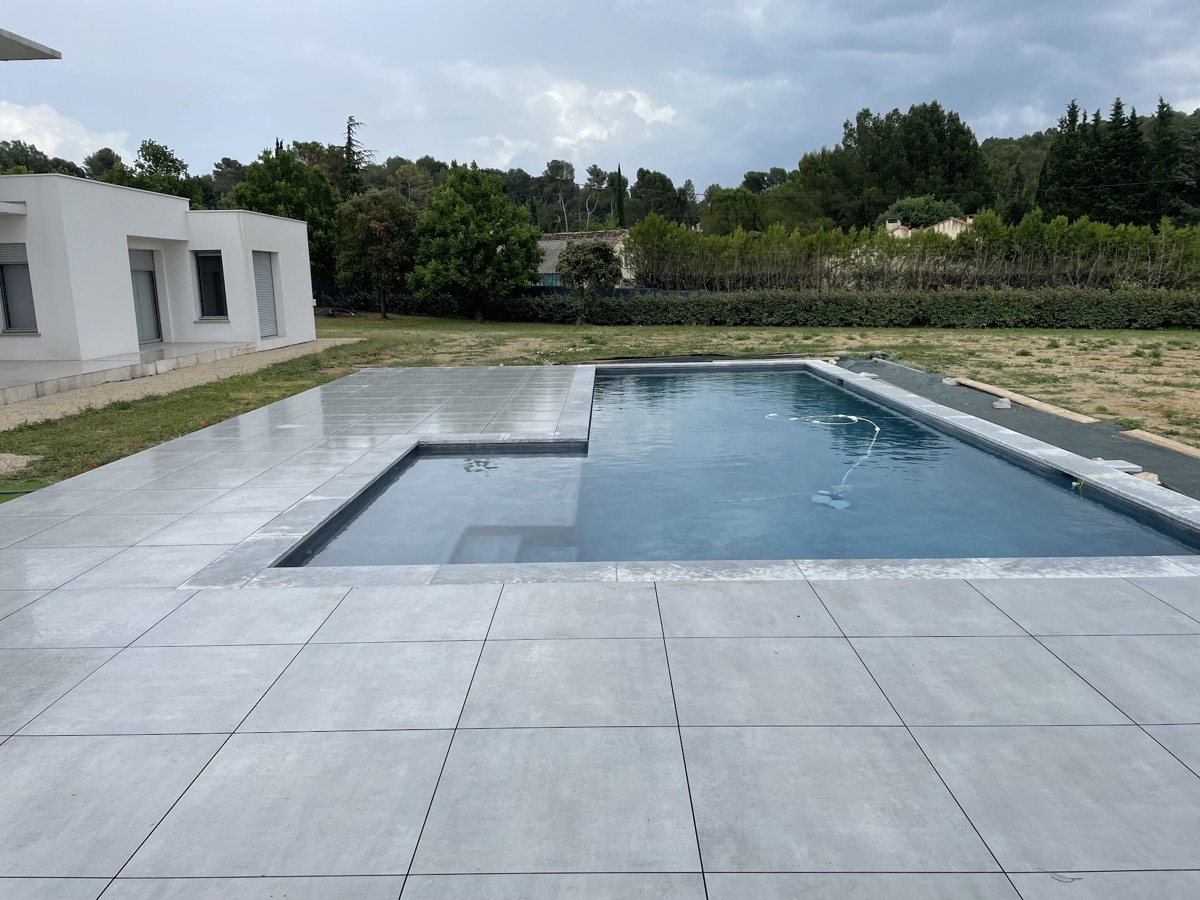 Piscine moderne et plage en grès cérame grand format